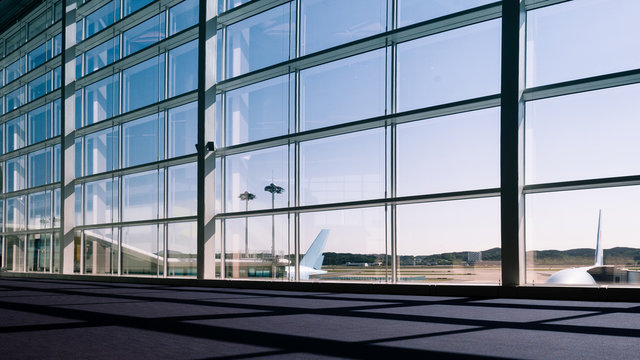 Walkway and glass curtain wall with Airplane background at Airport terminal, Travel concept with copy space. Silhouette background