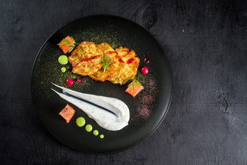 Meat steak with tartar sauce on black plate