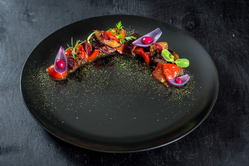Mixed vegetable dish with interesting presentation on black plate