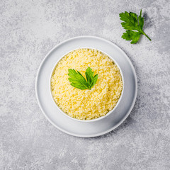 Couscous in a bowl on concrete background. Top view, space for text.