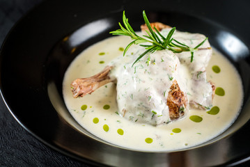 Chicken leg with sauce in black plate