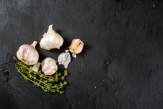 A garlic flatlay on black background. Top view. Copy space