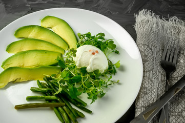 Poached egg with vegetables, avocado green beans and children's salad. The view from the top. Natural food