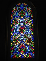 Stained glass. The stained glass window is made with a beautiful ornament on the glass. Ornament made of blue, red, yellow and other colors.