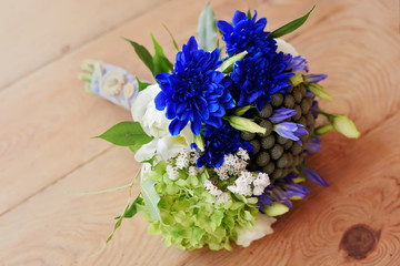 rustic wedding bouquet with blue asters flowers on wooden background