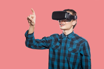 Young man with vr headset on pink background.