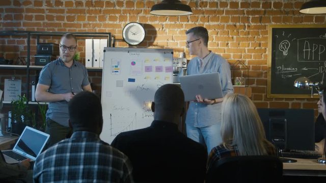 A multiracial group of people in the office makes analysis of the market and develops a strategy for the development of mobile software