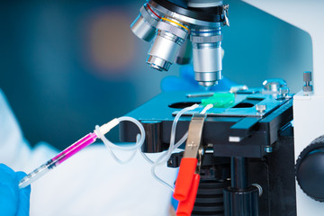 technician girl with microfluidic device LOC in microbiological lab