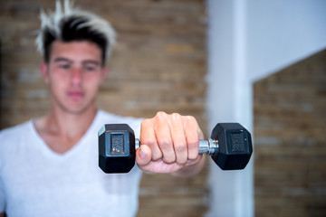 Closeup of man's hand holding dumbbell in the gym