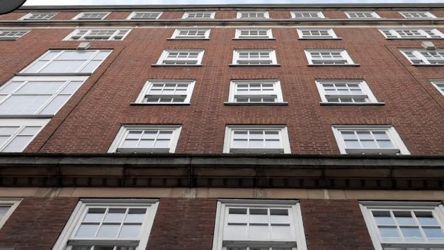 Low Angle View of Building Facade with Windows (Panning Up)