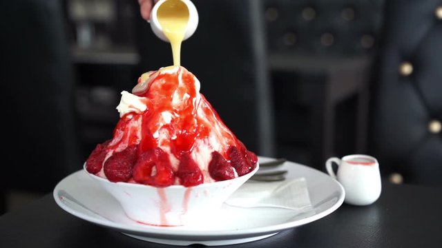 pouring sauce to top of shaved ice or strawberry bingsu fresh milk flavor