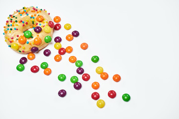 Appetizing golden donut sprinkled with colorful chocolate pellets.