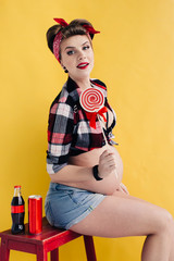 pregnant girl in the style of pin-up with a bottle of soda and lollipop