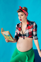 Pregnant girl on blue background in pin-up style