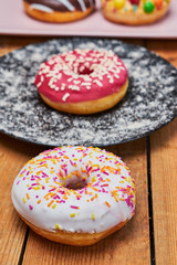 Four appetizing donuts lie on ceramic plates.