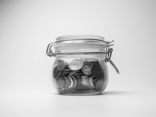 Saving money concept, coins in Glass Jar, White and black