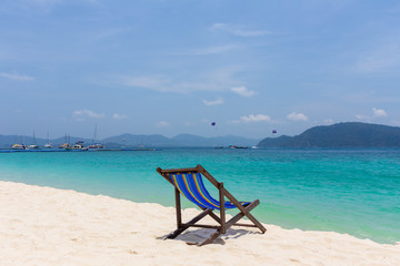 A beautiful empty chaise longue stands on the beach at the seaside.