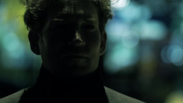 Scary man at night in city looking victim being aggressive