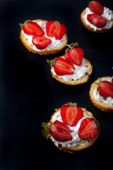  Fluffy buttermilk biscuits shortcake with red ripe strawberries and fresh whipped cream on a black background