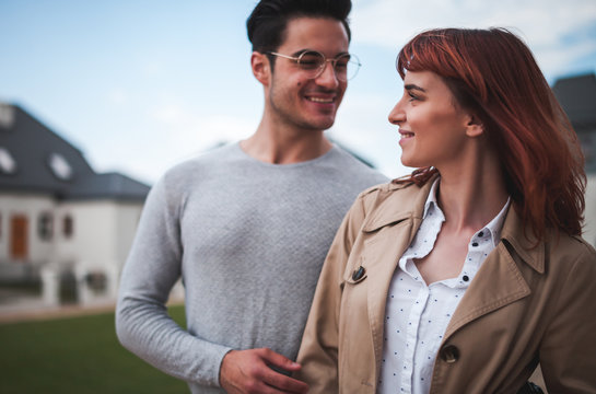 Happy couple walking at residential area in front of their new home - Powered by Adobe