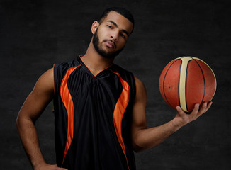 Portrait of an Afro-American sportsman. Basketball player in sportswear with a ball