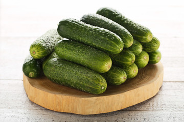 Fresh cucumbers on brown cutting board