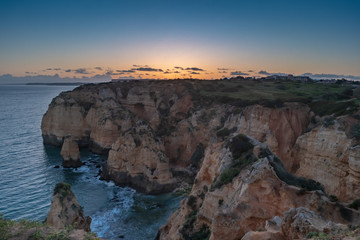 Fototapeta na wymiar Sunset over the cliffs and beaches by Atlantic Ocean, Lagos, Algarve, Portugal