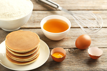 Tasty pancakes with eggs and cup of tea on grey wooden table