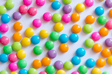 Pile of colorful sweet candy chocolates coated on white paper. colourful collection