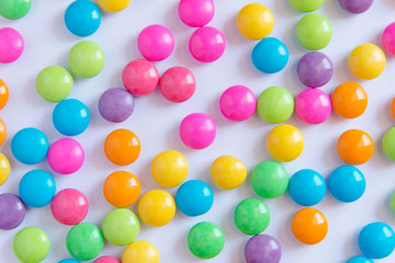 Pile of colorful sweet candy chocolates coated on white paper. colourful collection