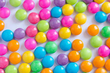 Pile of colorful sweet candy chocolates coated on white paper. colourful collection