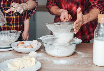 Dad sifts flour in the kitchen