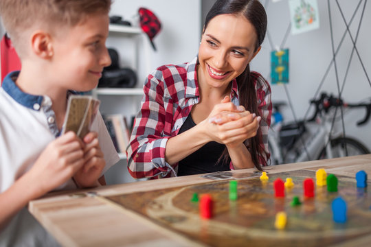 Mother and son playing modern board game in teenage room at home