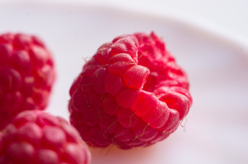 raspberries on a white saucer close up