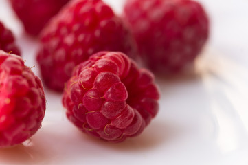 raspberries on a white saucer close up