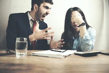young angry man and woman in office