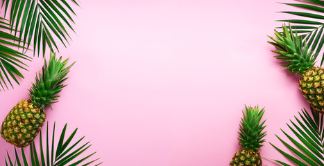Pineapples and tropical palm leaves on punchy pastel pink background. Summer concept. Creative flat lay with copy space. Top view - Powered by Adobe