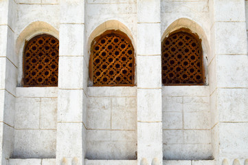 The texture of a brick wall and three wooden brown old seniors of an ancient carved Arab Islamic Islamic triangular window with ornaments and patterns. The background.