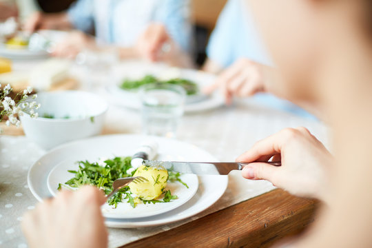Crop view of person hands cutting food on plate indoors