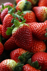 Fresh strawberries on brown wooden background. A group of strawberries
