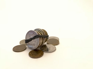 Iron coins bandaged with an elastic band for money and coins lying next to a white background