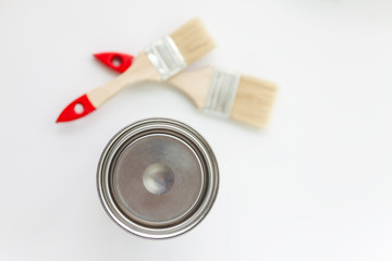 Paint brush and can of paint on a white background