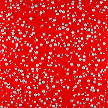 Texture of fabric with chaotically embroidered white pearls of different sizes. Red elegant background. Illustration.