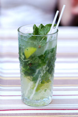Fresh mojito from mint and lime in a glass on the table.