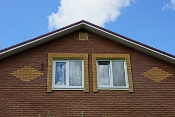 part of a brown loft of bricks with windows on a sky background