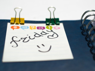 Fototapeta premium the name of the day of the week written on a sticky sheet in a blue notebook with springs