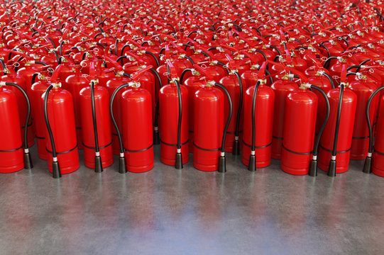 A lot of fire extinguishers on a grey background.