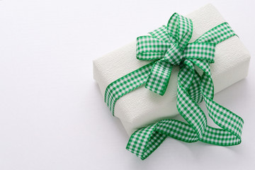 Gift with checkered green ribbon on a white background. Father’s day. Concept for Cards, Posters, Invitations. Dad, Man Birthday. Surprise. Christmas, New Year Present.