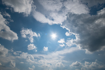 Fototapeta na wymiar Blue sky with fluffy clouds and sun