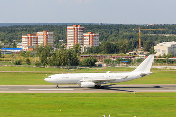 The white passenger plane is moving along the taxiway and getting ready to take off